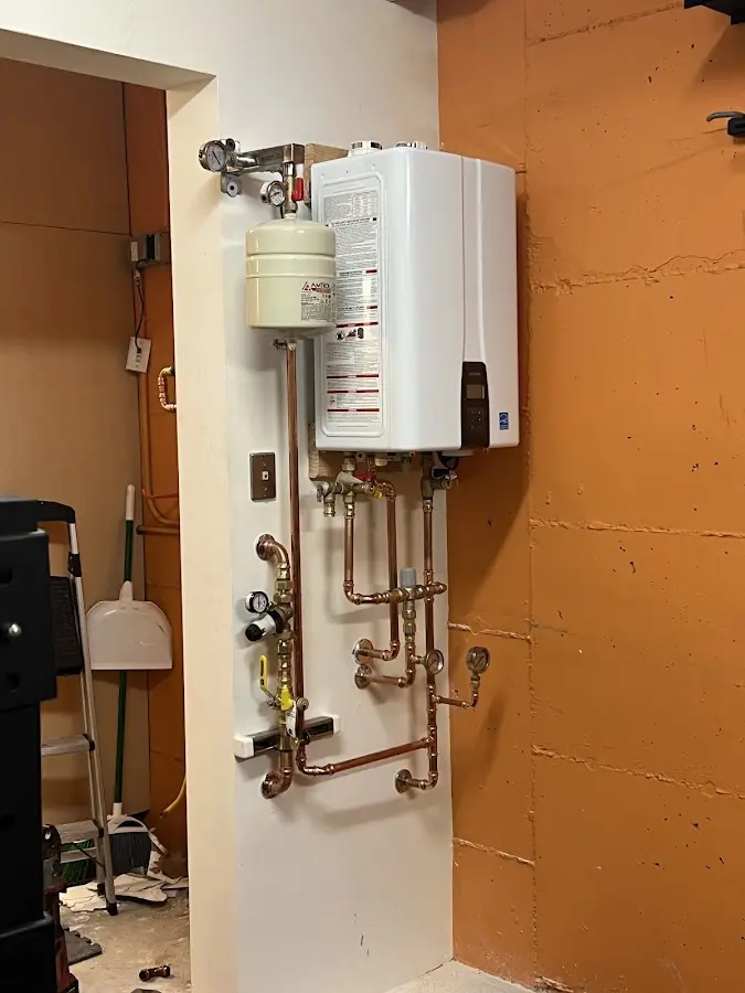 Plumbing technician inspecting water heater connections in Tiburon
